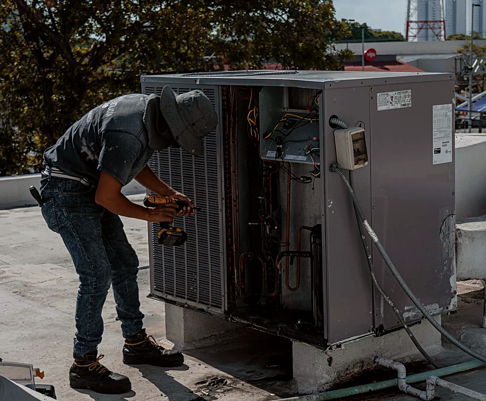 HVAC technician servicing an outdoor air conditioning unit