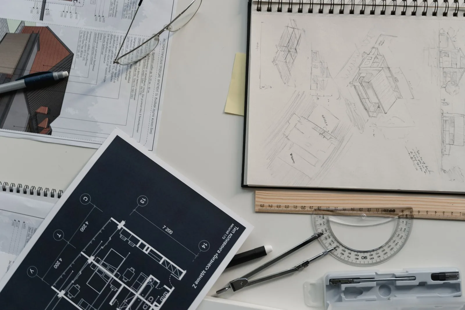 Architectural blueprints, sketches, and drafting tools spread across a desk