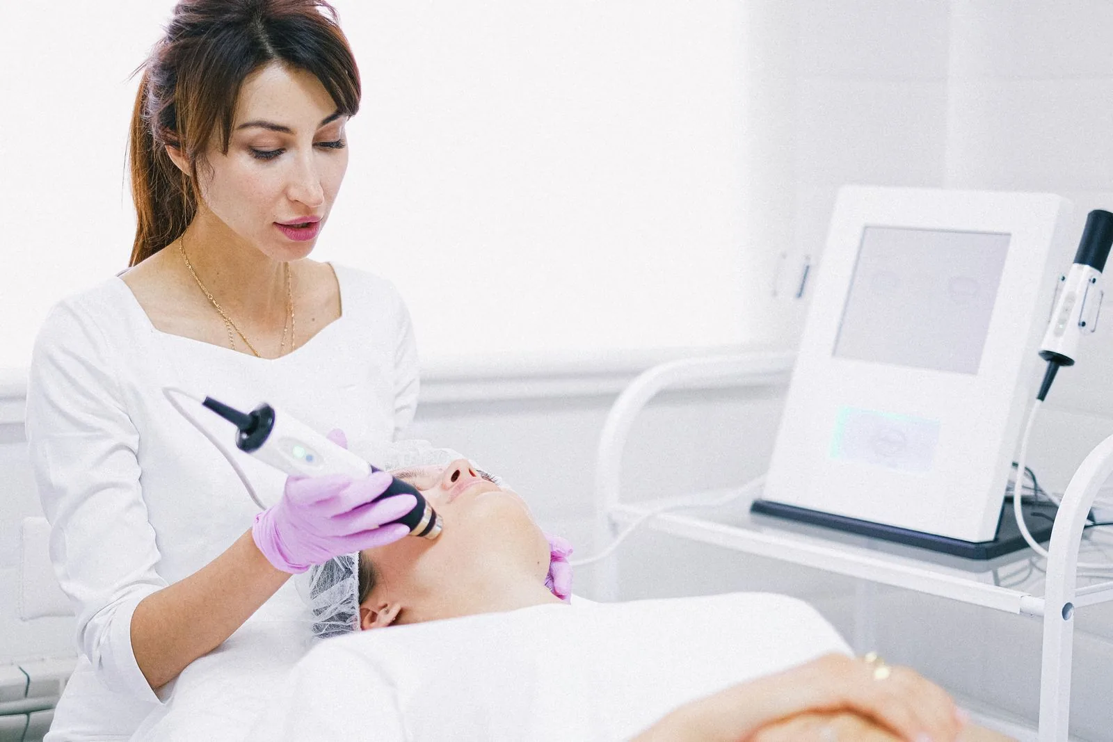 Esthetician performing a facial treatment on a client in a clinic