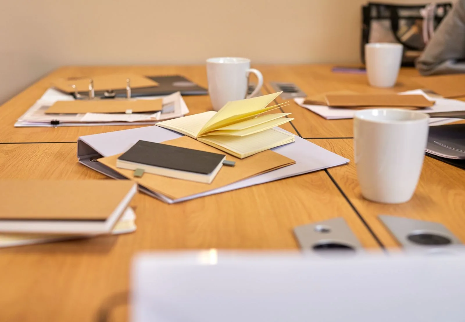 Overhead view of a business meeting table with laptops, notebooks, and coffee