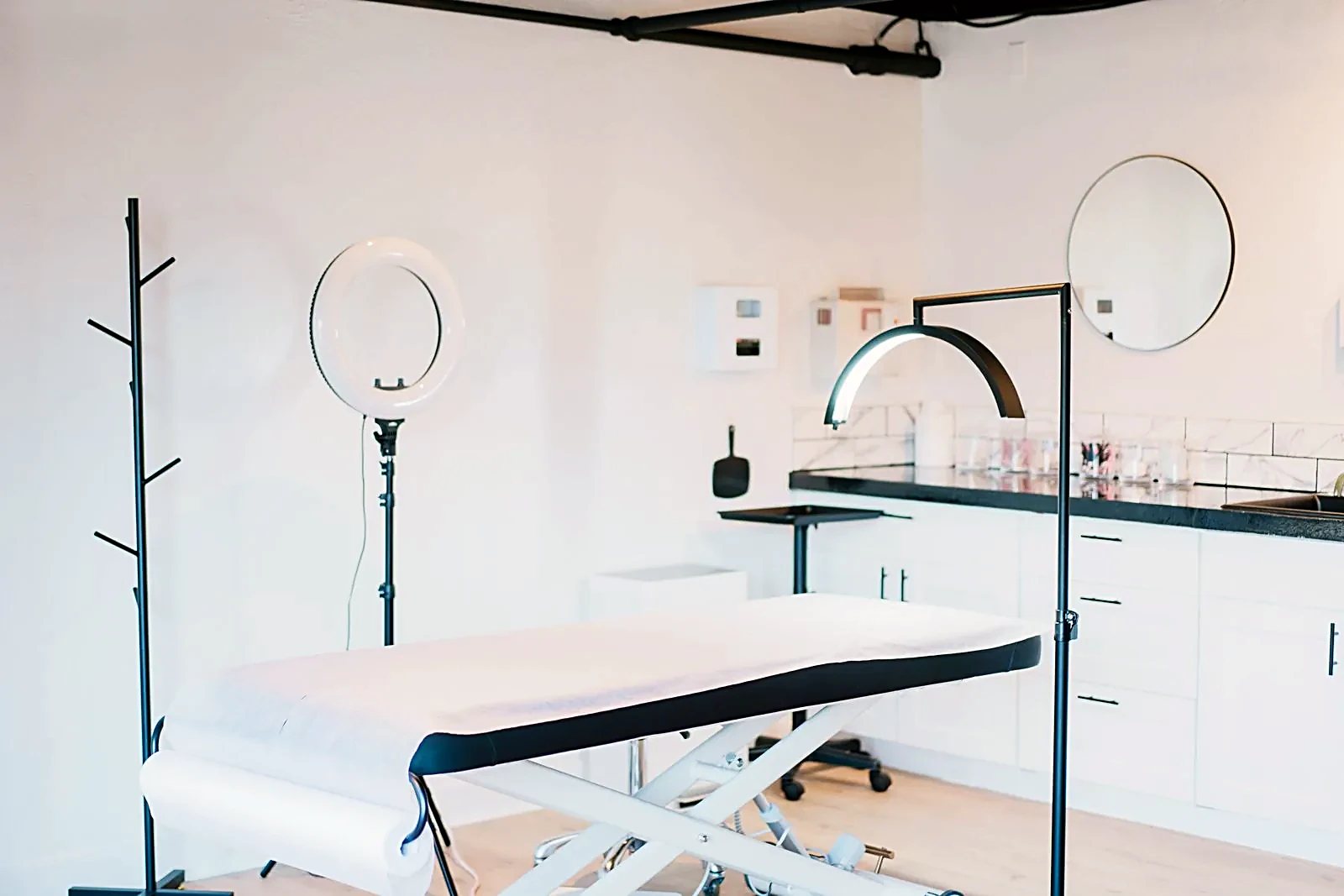 Bright, modern med-spa treatment room with treatment bed and studio lighting